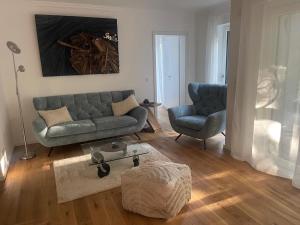 a living room with a couch and two chairs at Villa Chloe Binz - App 6 am Kurpark in Binz