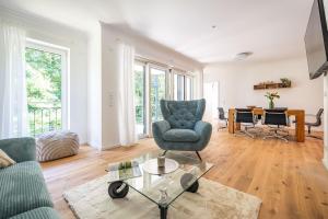 a living room with a couch and a chair and a table at Villa Chloe Binz - Appartement 6 in Binz
