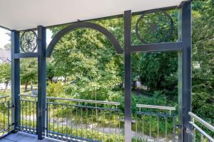 an open gate to a balcony with trees at Villa Chloe Binz - Appartement 6 in Binz +12 photos