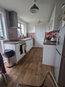 une cuisine avec des appareils blancs et un parquet dans l'établissement Single room with beautiful garden, à Édimbourg