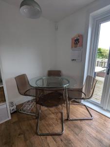une table et des chaises en verre dans une chambre avec fenêtre dans l'établissement Single room with beautiful garden, à Édimbourg 8 autres photos