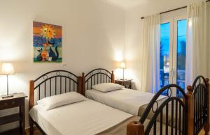 two beds in a room with a window at Parys Villas in Tsilivi