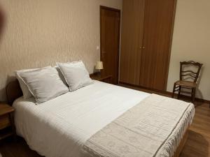 een slaapkamer met een bed met witte lakens en een stoel bij Varandas do Tamega in Mondim de Basto +27 foto's