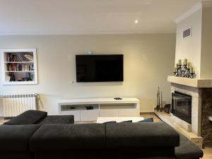 een woonkamer met een bank en een flatscreen-tv bij Varandas do Tamega in Mondim de Basto