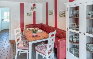 a dining room with a red couch and a table at Lovely Home In Nordstrand Nordstrand in Kiefhuck