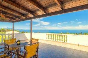 a patio with a table and chairs and the ocean at Parys Villas in Tsilivi