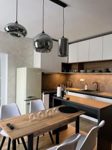 a kitchen with a wooden table and white cabinets at Apartman na namesti in Opočno