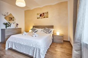 a bedroom with a white bed and two night stands at La Piccola Loggia in Torrita di Siena
