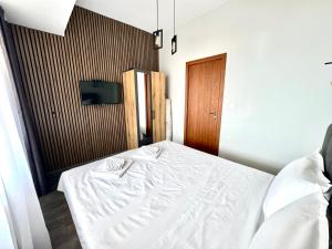 a bedroom with a white bed and a wooden door at Апартамент СВЕТИ ВЛАС 1 in Sveti Vlas