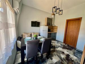a dining room with a table and chairs and a refrigerator at Апартамент СВЕТИ ВЛАС 1 in Sveti Vlas