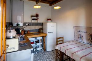 a small kitchen with a refrigerator and a table at Rozmaringos vendégház Szenna in Szenna