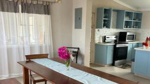 a kitchen with a table with a vase of flowers on it at Welcome to Hope Winds, a charming property ranch-style house on a seren in Christ Church