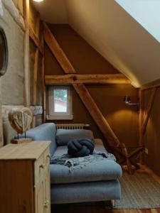 una sala de estar con un sofá azul en un ático en Ferienwohnung Alte Schule Chorin Schorfheide, en Chorin