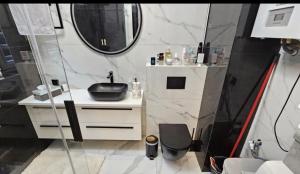 un bagno con lavandino e specchio di Apartament De LUX Wrzosowo Dziwnówek a Dziwnówek