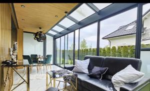 un soggiorno con divano e finestre in vetro di Apartament De LUX Wrzosowo Dziwnówek a Dziwnówek