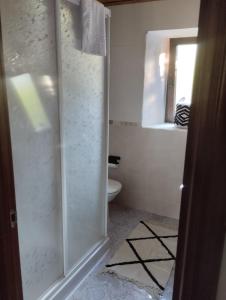 a bathroom with a toilet and a glass shower door at Casa de Valeria in Tomiño