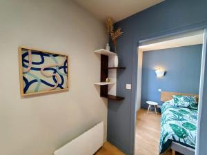 - une chambre avec un lit et un mur avec des étagères dans l'établissement Saint Jean - La Rivière- T2 tout neuf, à Niort