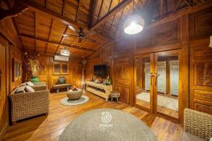 a living room with wooden walls and a ceiling at Rumah joglo in Candidasa