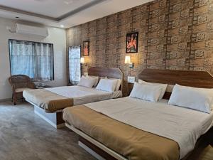 a bedroom with two beds in a room at Ellora Heritage Resort in Ellora +36 photos