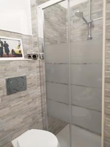 a bathroom with a toilet and a glass shower at Center Vicolo Suite Apartment with Parking in Modena