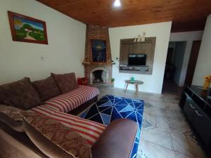 Una sala de estar con un sofá y una chimenea. en Casa Vista Verde, en Camanducaia