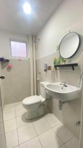un bagno con un water, un lavandino e uno specchio di RizQ RestHomestay a Semenyih Altre 18 foto
