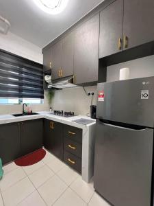 una cucina con armadi grigi e frigorifero di RizQ RestHomestay a Semenyih