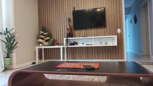 a living room with a coffee table and a tv at Quarto em apartamento no Centro in Passo Fundo