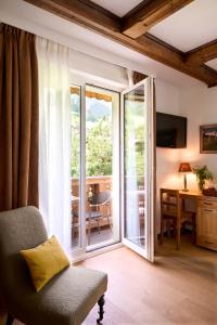 a living room with a chair and a sliding glass door at Maison d'h&ocirc;tes Ermitage in Chateau-d'Oex