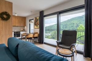 a living room with a blue couch and a table with chairs at Widokowe wzgórze - Sun&Sport in Szczyrk