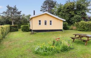 a yellow house with a picnic table in a yard at 2 Bedroom Cozy Home In Allinge in Allinge