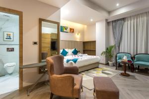 a bedroom with a bed and a desk and a chair at De Crown Inn in Jogīkuti +45 photos