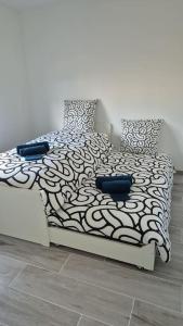 a bedroom with a bed with a black and white comforter at Grande maison en sologne in Romorantin