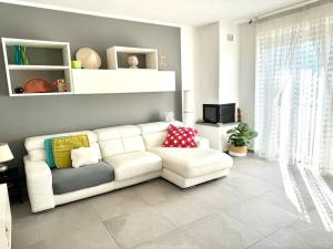a living room with a white couch and a tv at Casa Anna Asciano in Asciano Pisano