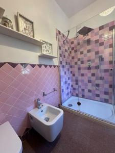 a pink bathroom with a sink and a tub at Casa Anna Asciano in Asciano Pisano +10 photos