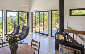 un soggiorno con camino, tavolo e sedie di 4 Bedroom Gorgeous Home In Tromøya a Veden