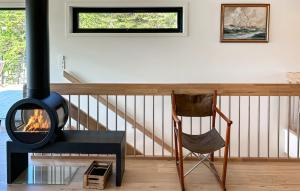 un soggiorno con camino e sedia di 4 Bedroom Gorgeous Home In Tromøya a Veden