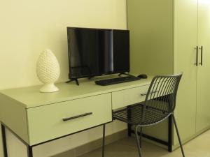 a desk with a computer monitor and a chair at B&B Case Marcapane in Sommatino