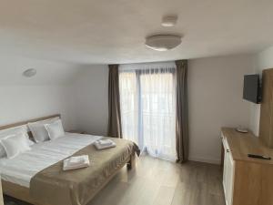 a bedroom with a bed with two towels on it at Casa Didi in Zărneşti