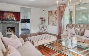 a living room with white furniture and a fireplace at 4 Bedroom Cozy Home In Angered in Angered