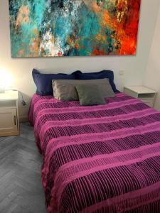 - une chambre avec un lit violet orné d'une peinture murale dans l'établissement Puerta del Sol -de la Cruz Isabel I0 & Parking, à Madrid