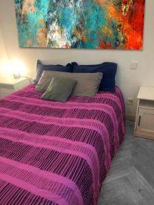 - une chambre avec un lit violet orné d'une peinture murale dans l'établissement Puerta del Sol -de la Cruz Isabel I0 & Parking, à Madrid