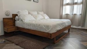 Una cama con sábanas blancas y almohadas en un dormitorio. en Appartement hôtel de luxe 974, en Antananarivo