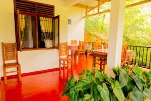 a dining room with a table and chairs on a balcony at Aroma Heaven Homestay in Ella