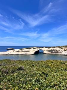 a group of rocks in the water near the ocean at Casa dell arco in S'archittu Cuglieri