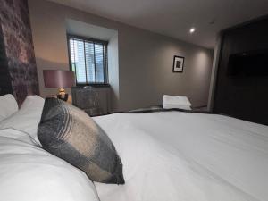 a bedroom with a large white bed and a window at Richmond Park Hotel in Boʼness