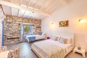 a bedroom with two beds and a stone wall at Alacati Eski Ev Hotel in Alacati