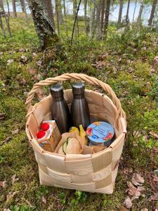 een mand gevuld met flessen en voedsel op de grond bij Metsäsydän mökki 4 Mettäpöyröö in Puumala