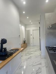 a kitchen with white walls and a marble floor at Alba White in Rome