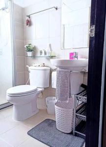 a white bathroom with a toilet and a sink at Studio 1 bed heart old town phuket convenience in Ban Sam Kong